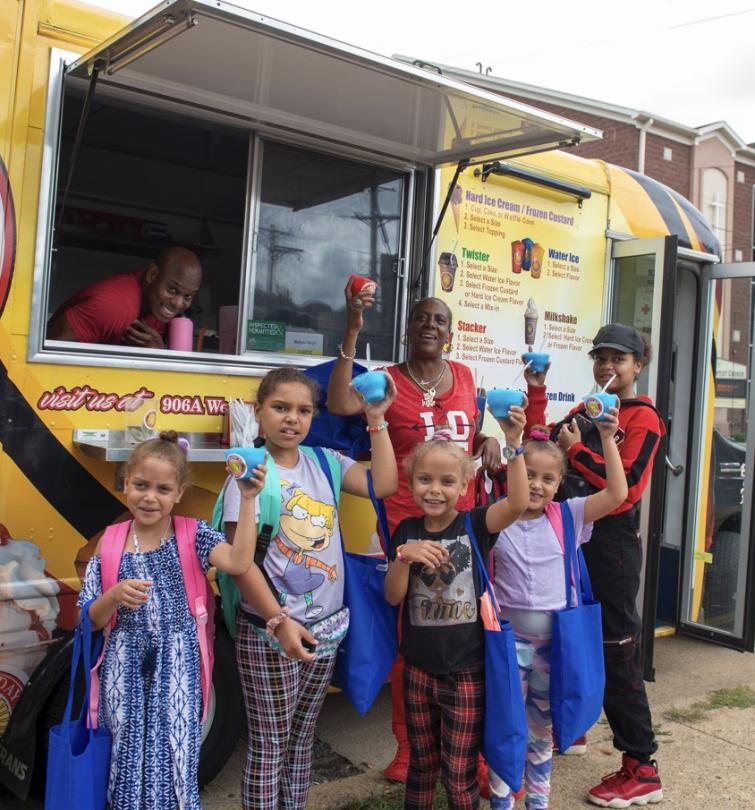 attendees at a block party celebrate getting water ice