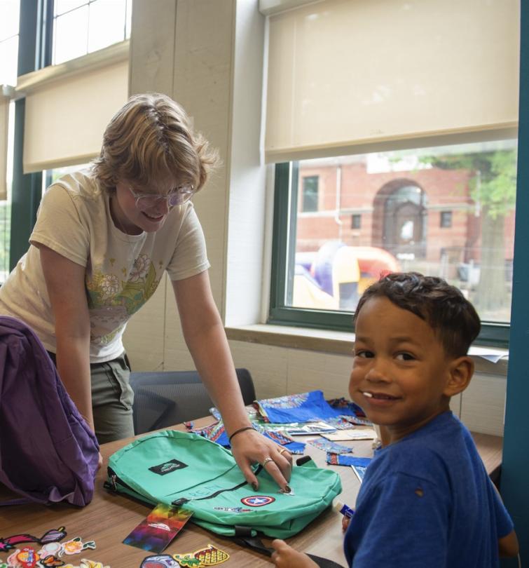 kids decorate backpacks at a back to school block party