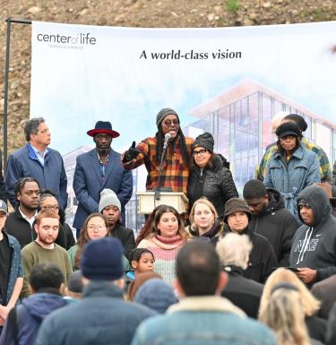 tim smith speaks on a stage in hazelwood green at the announcement event of the new center of life location